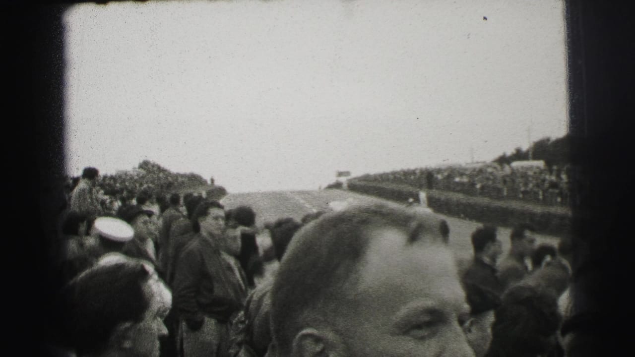 Spectators gathered beside a road course with a man's face in the foreground.