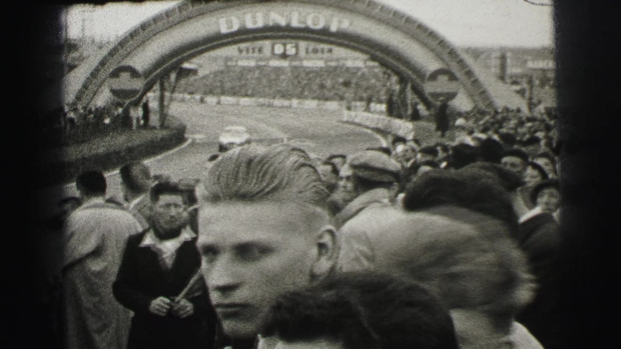 Spectators stand beneath a Dunlop arch near the race circuit.