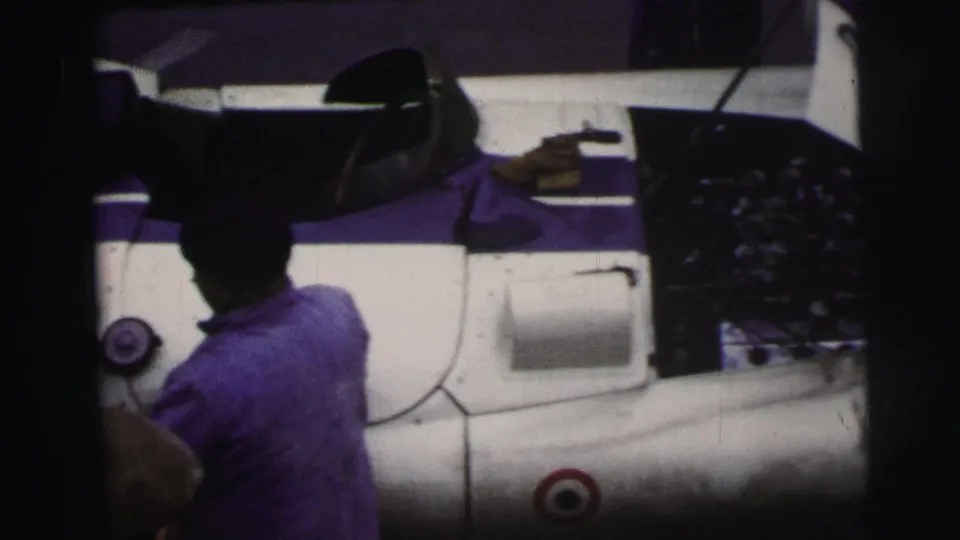 Final 1954 Le Mans view from above shows crew activity around a white race car with an open hood, roundel marking, and exposed engine.