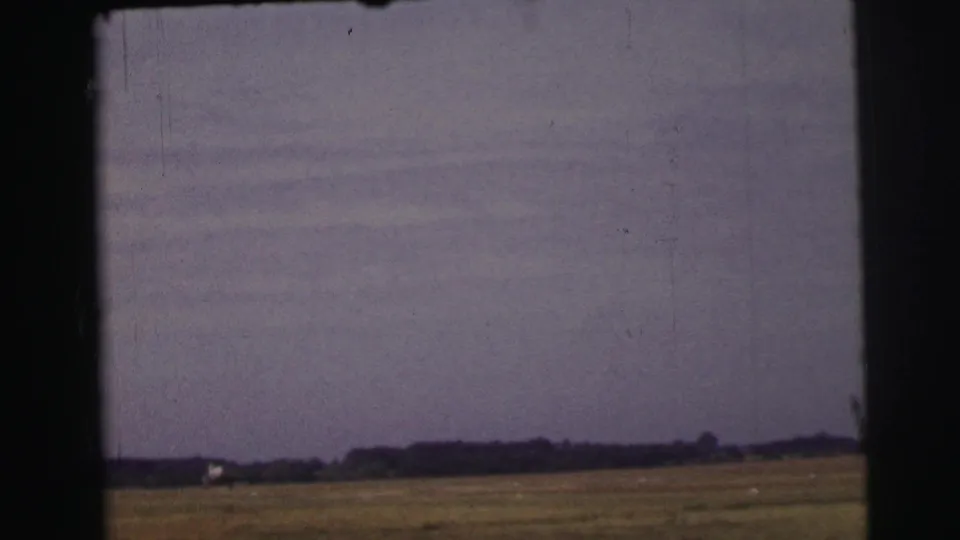 The final frame shows the grass runway and low horizon, with the aircraft now small and distant against the muted sky.