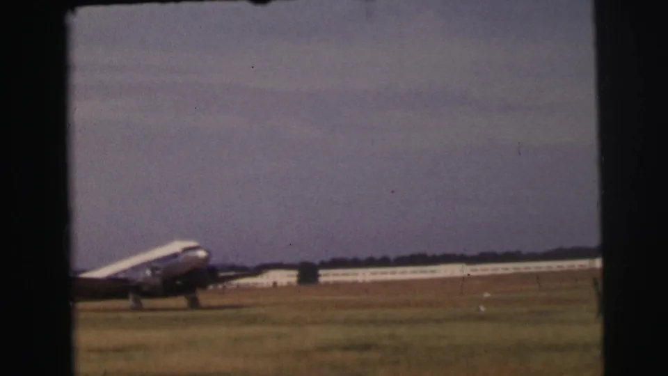 A closer 8mm view shows the nose and fuselage of the passenger plane crossing the grassy Le Mans airfield.
