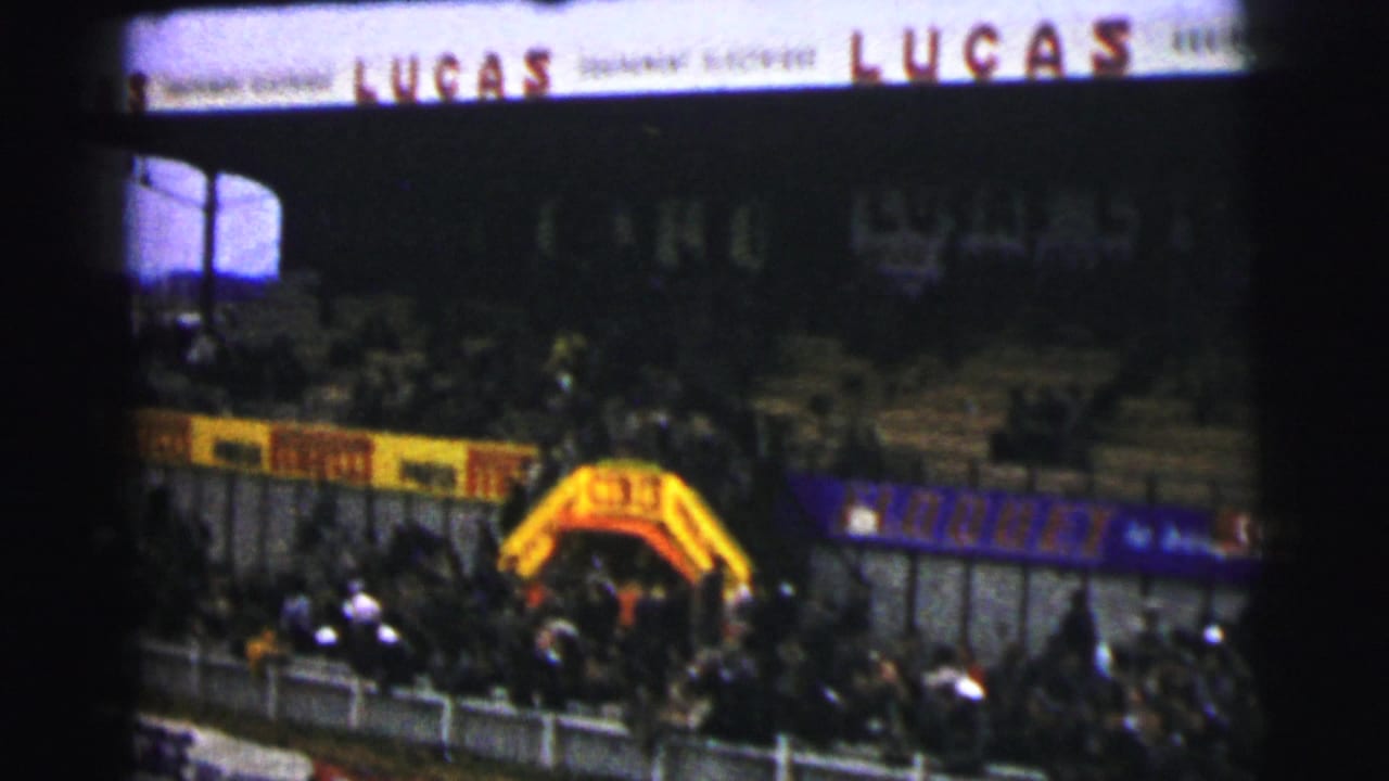 Lucas sign above a crowded trackside spectator area and yellow arch.