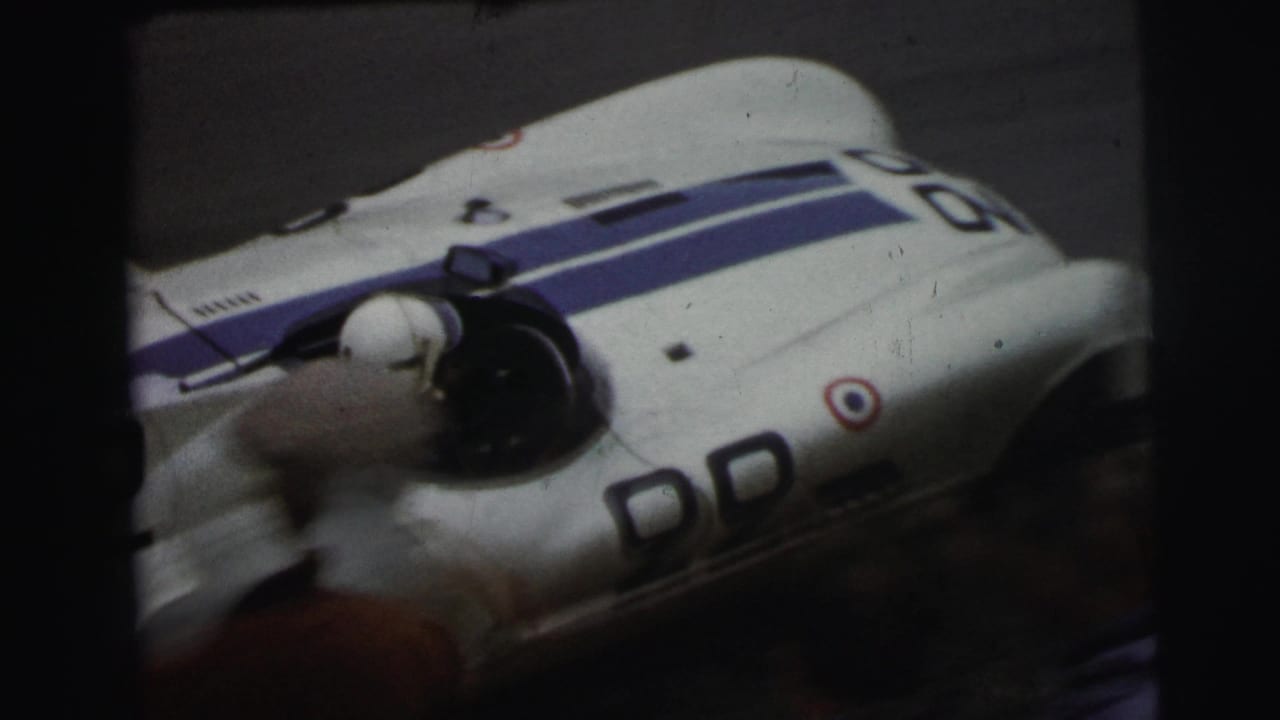 White and blue race car seen close-up with a blurred spinning front section.