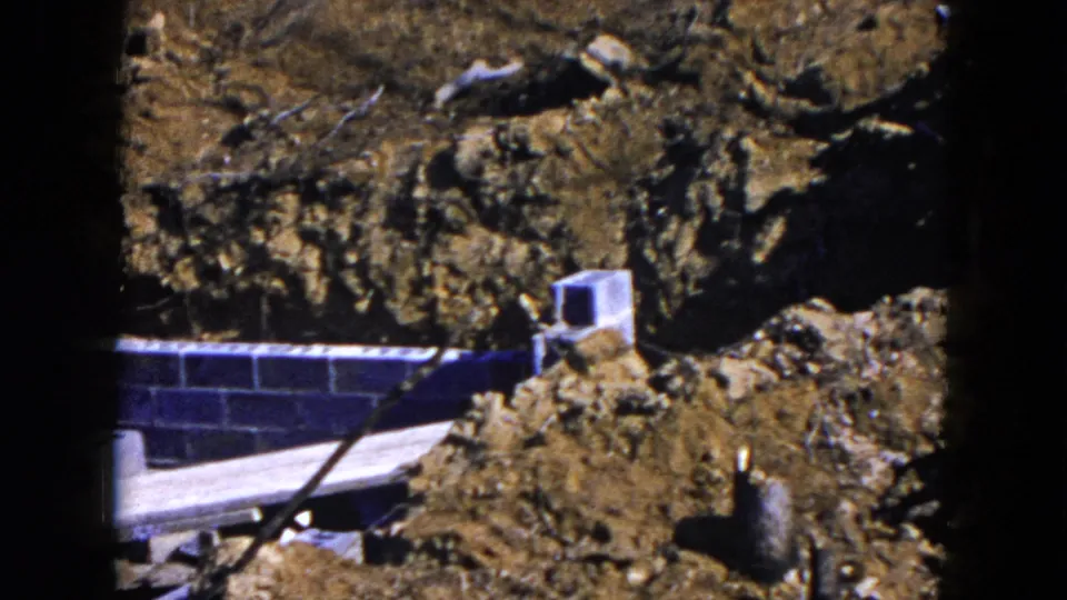 A partially built foundation in Hicksville, New York, with cinder blocks, wood planks and earth piled around the trench.