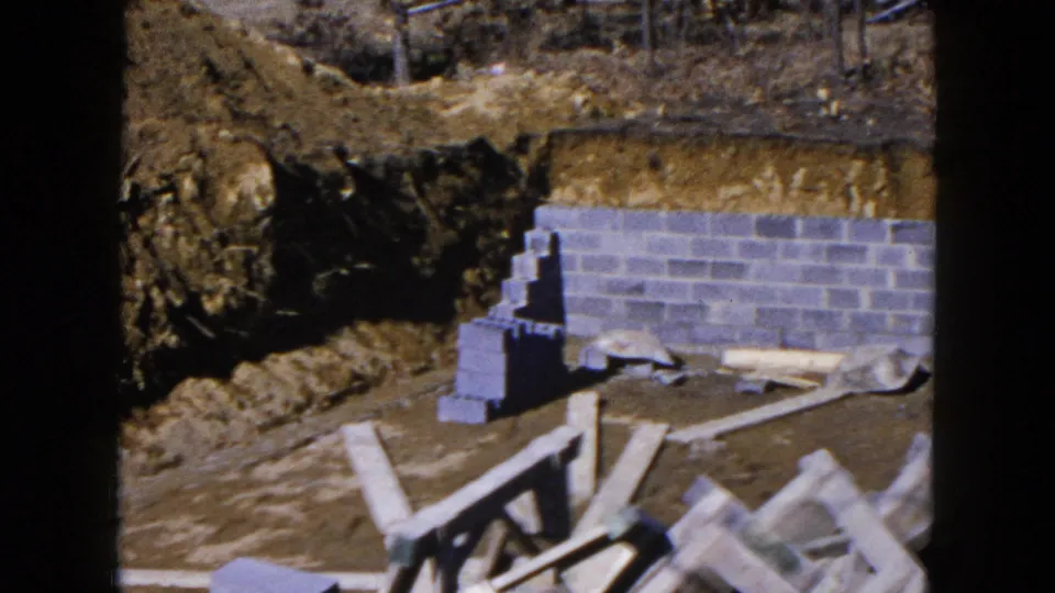 The final frame shows the cinder-block foundation and scattered lumber within the 1954 Hicksville residential construction scene.