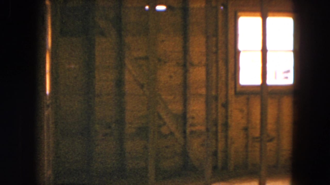 Unfinished wooden wall with a bright small window near the right side.