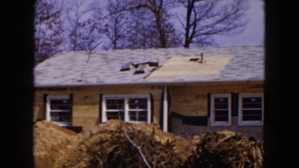 The Hicksville construction view continues, with a partially shingled roof, exposed wall sheathing, window frames, and earth piled across the foreground.