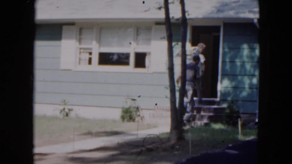 At the doorway of the Hicksville home, the two men pause with the appliance near the entrance in the final 1954 frame.