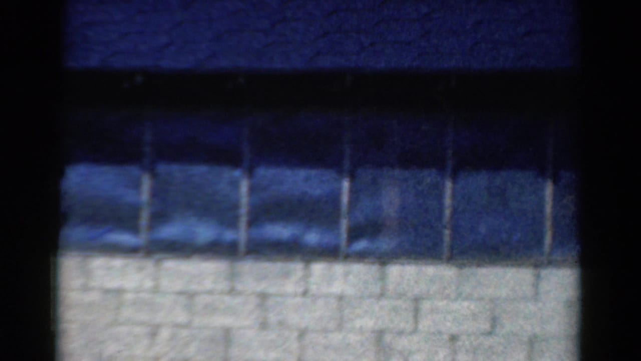 Dark blue window panes above a white masonry wall with black borders around the frame.