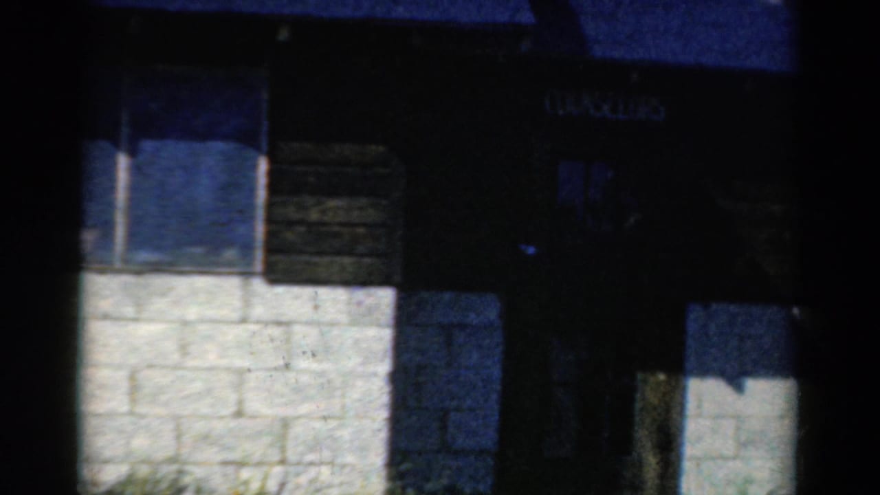 Camp building doorway area with windows, block wall, and dark siding.