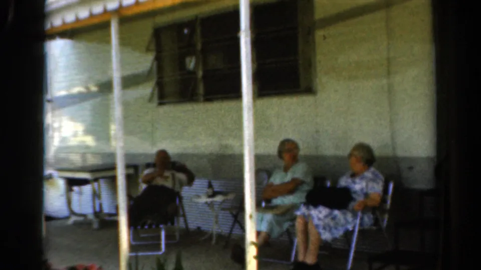 A wider 1954 California porch view shows three older women seated in folding chairs near a small table and screened windows.