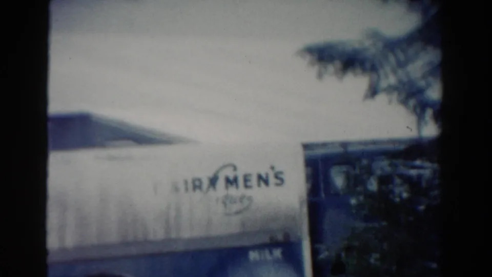 1954 Toledo frame showing the Fairmen's Dairy truck lettering, snowy roofline, and dark tree branches at the right edge.