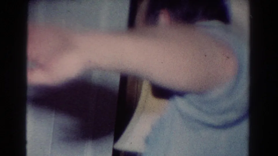 The final frame shows a blurred person moving close to the camera near dark furniture in the same private 1954 Toledo interior.