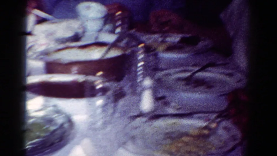 Close view of a 1950s family dinner table in Toledo with plates, serving dishes, cups, and a salt shaker visible.