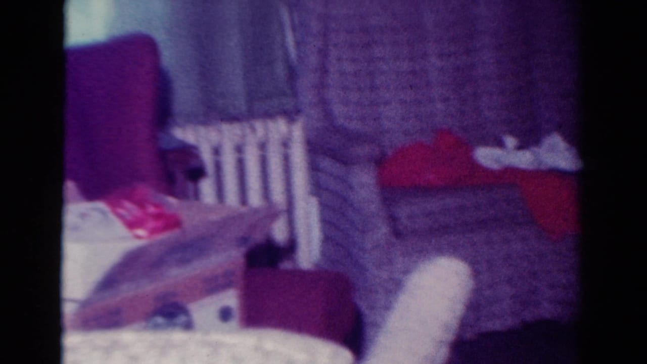 Patterned couch with gifts and wrapping paper beside a radiator and red fabric.
