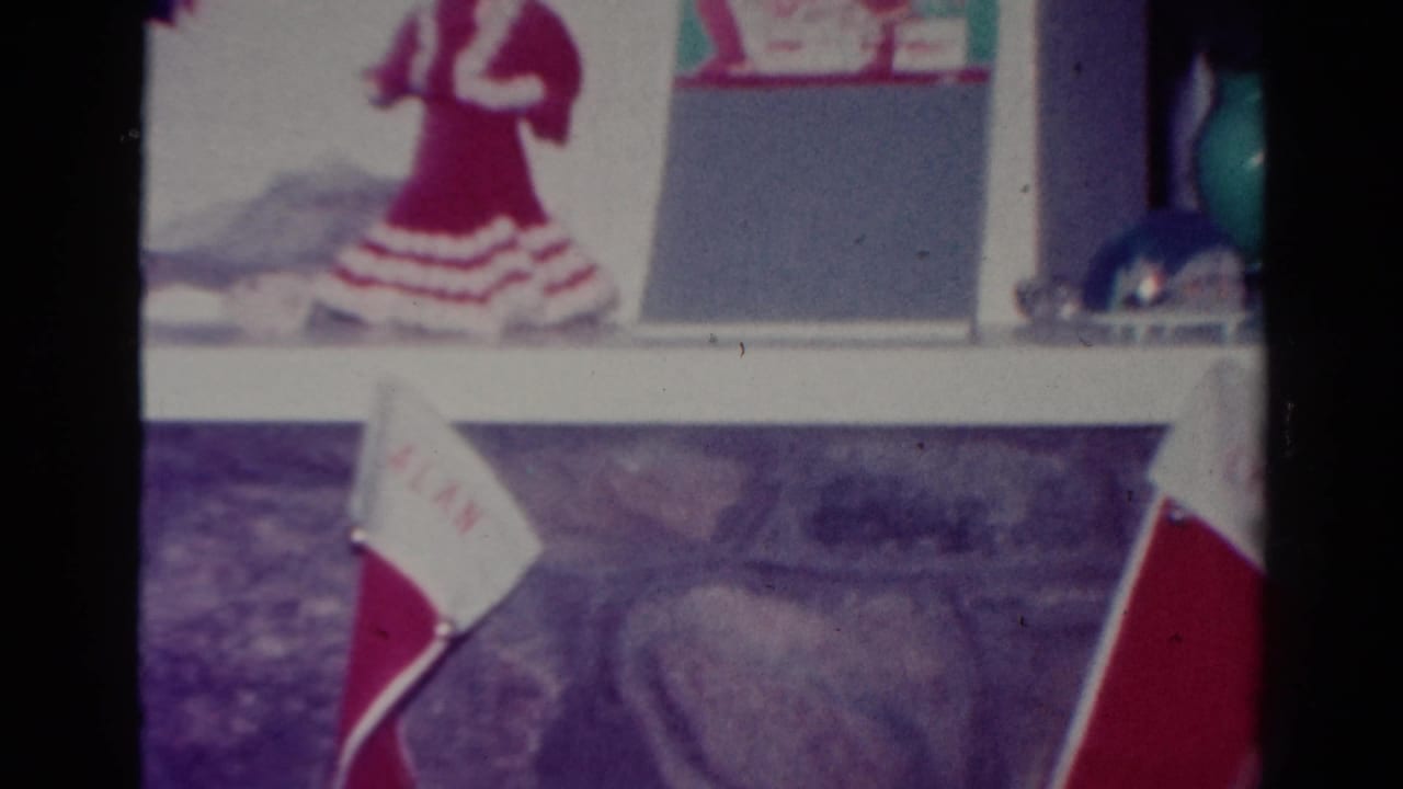 Mantel decorations above red-and-white stockings near a fireplace.