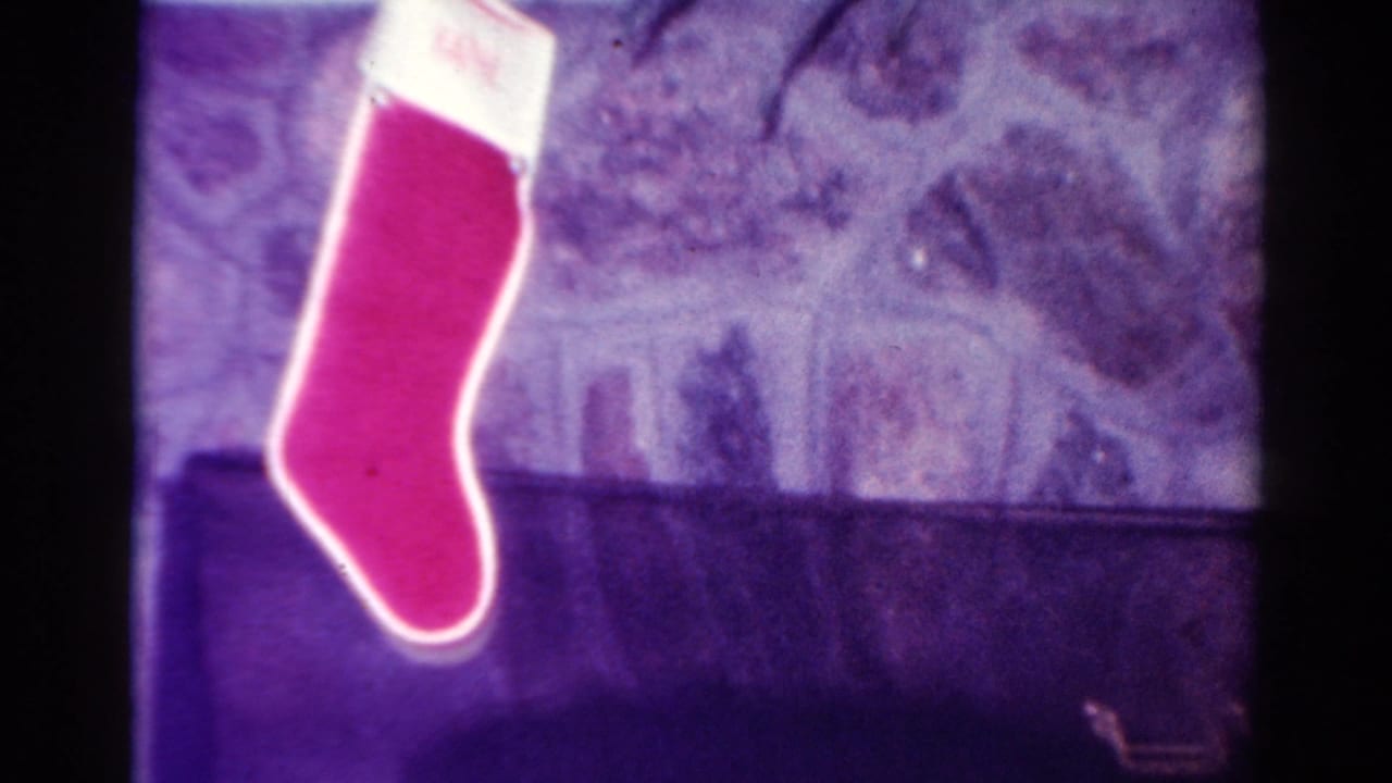 Red Christmas stocking hanging from a fireplace mantel in a private room.