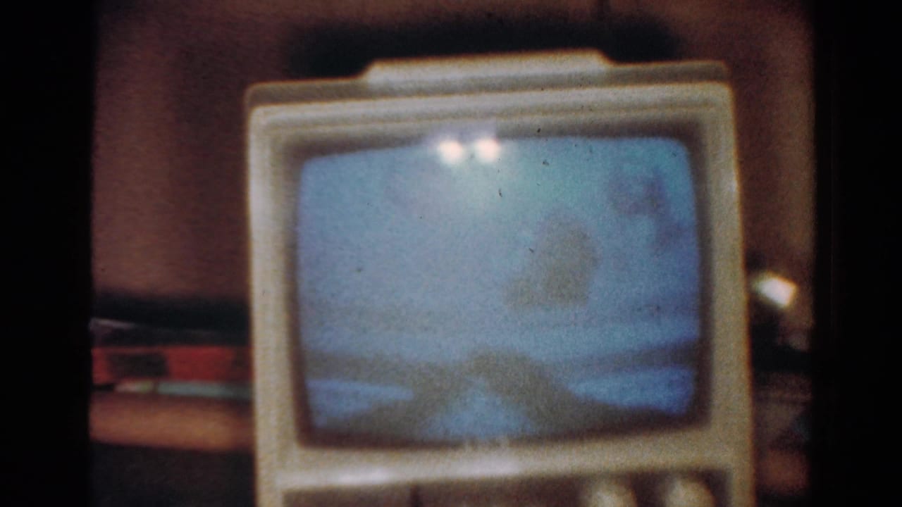 Vintage television screen glowing blue with soft shapes inside the picture area.