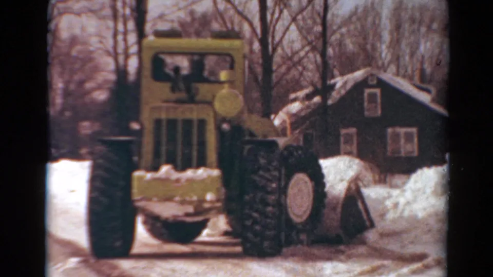 Front-facing 8mm frame of the yellow snow-clearing machine near a residential house in Toledo, Ohio, based on supplied metadata.