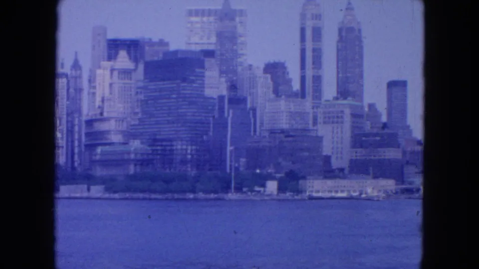 Blue-tinted 1954 8mm view of lower Manhattan skyline and waterfront from New York Harbor.