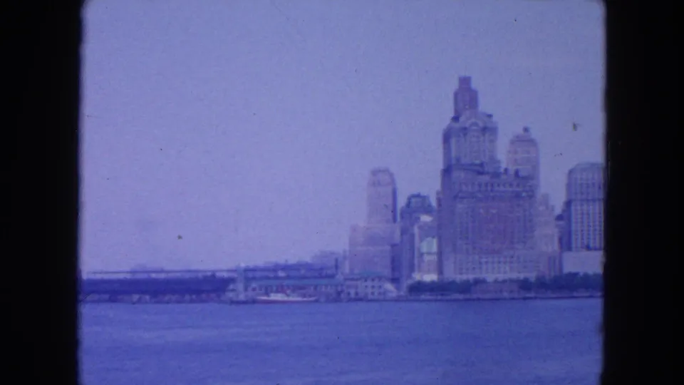 The final frame shows more open harbor water and a distant section of the New York City skyline in blue-tinted 8mm footage.