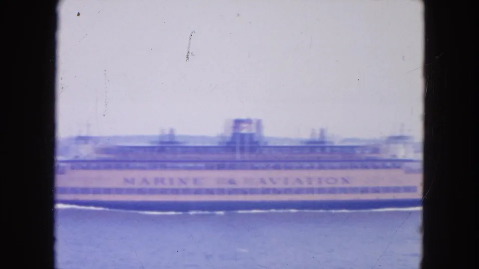 A large Marine & Aviation ferry or passenger vessel passes across New York harbor in soft 1954 8mm color.