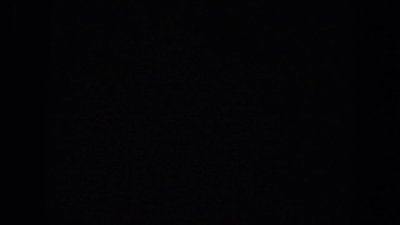 Mostly dark film frame with faint vertical edge detail.