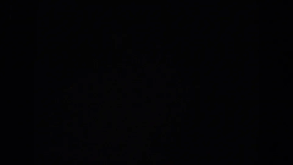 Dark 8mm frame from the New York City clip, with only faint film-edge texture visible.