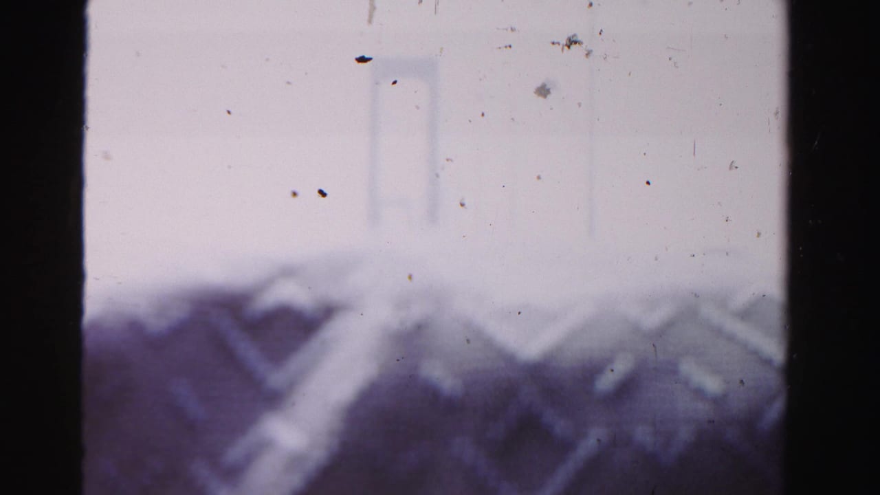 Hazy 1955 Dade County home-movie view of a suspension bridge span with pale sky and visible film dust.