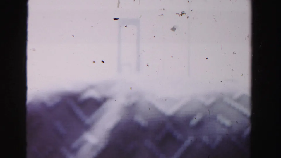 Hazy 1955 Dade County home-movie view of a suspension bridge span with pale sky and visible film dust.