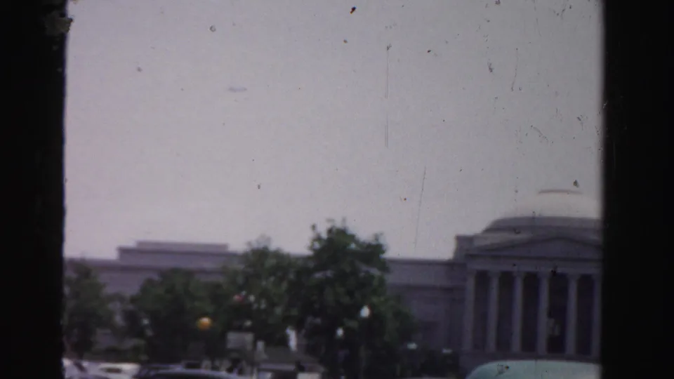 1955 Dade County street view of a domed, columned building behind trees and roadside traffic.