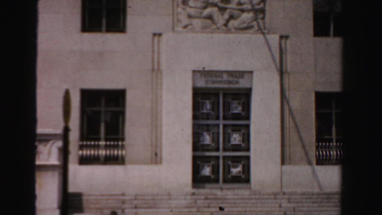 Building entrance with steps, gridded doors, windows, and relief panel above.