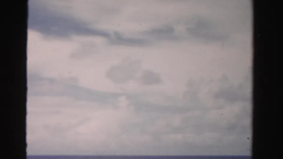 Opening 8mm frame with cloudy sky and a washed horizon, likely just before the car scene in Dade County, Florida.