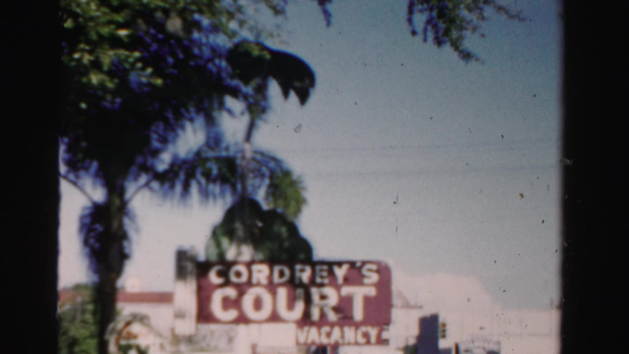 Cordrey's Court sign and vacancy lettering beside palm trees and street buildings.