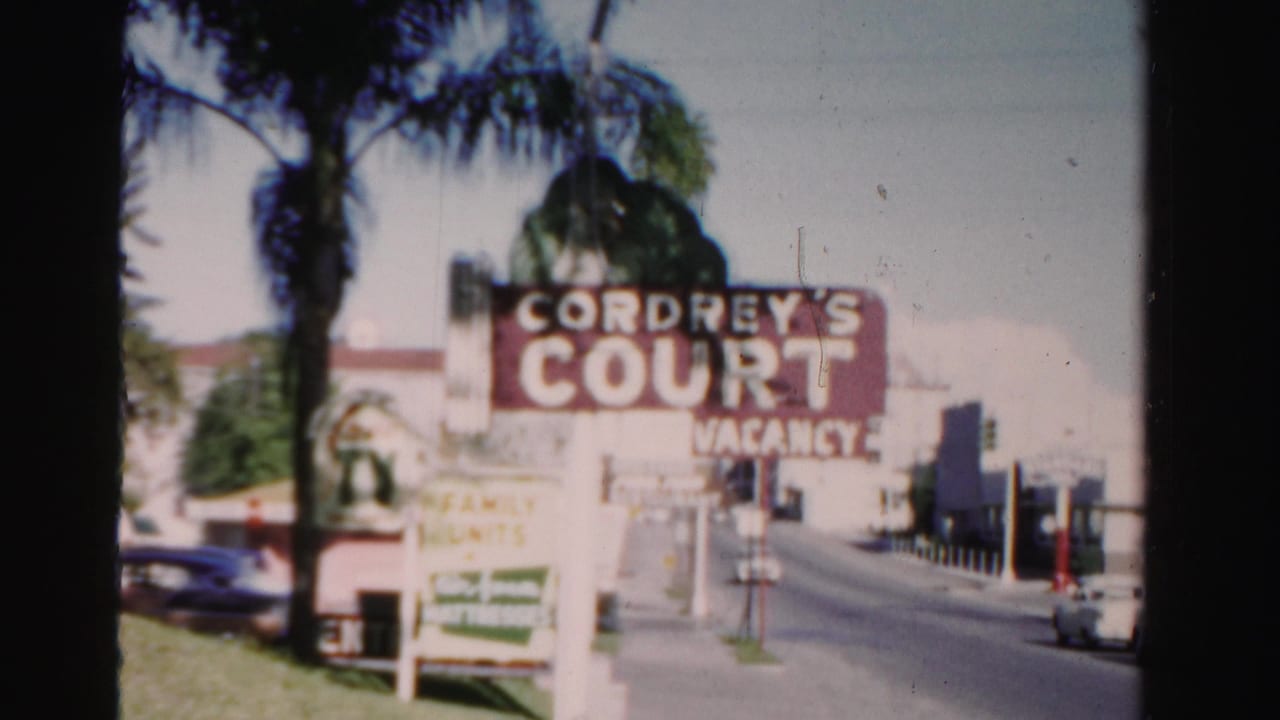 Cordrey's Court vacancy sign beside a palm-lined street and low buildings.
