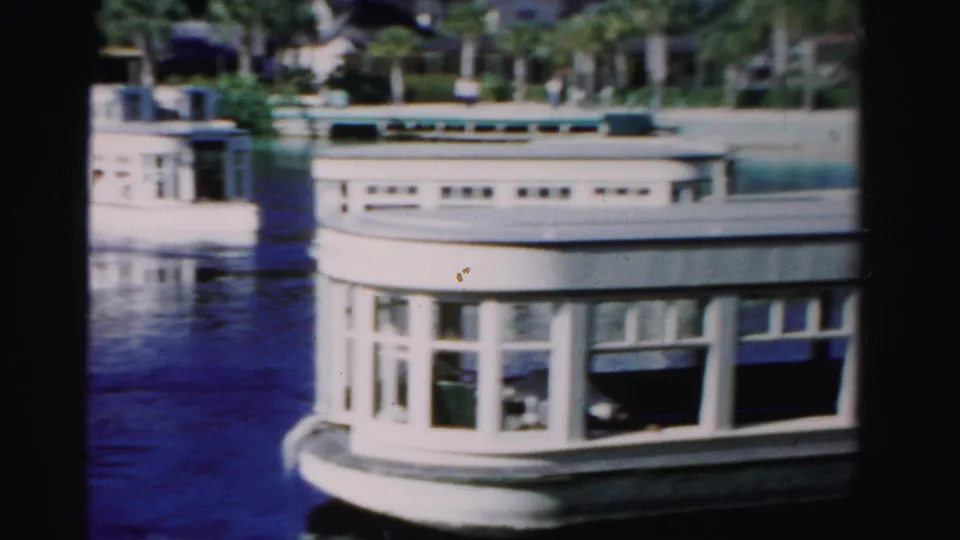 A closer view shows the white boat's rounded rear section and windows as it continues past the Dade County shoreline.