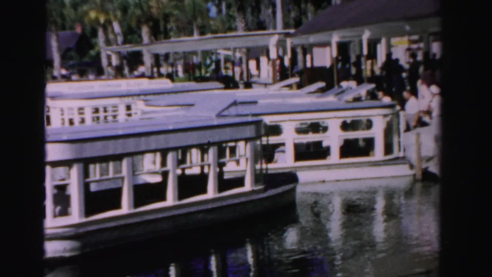White passenger boat at a Dade County dock, with visitors standing along the pier and water reflecting the hull.