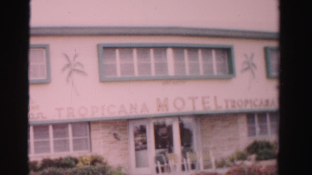 Tropicana Motel facade with green trim, signage, palm decals, and entry area.