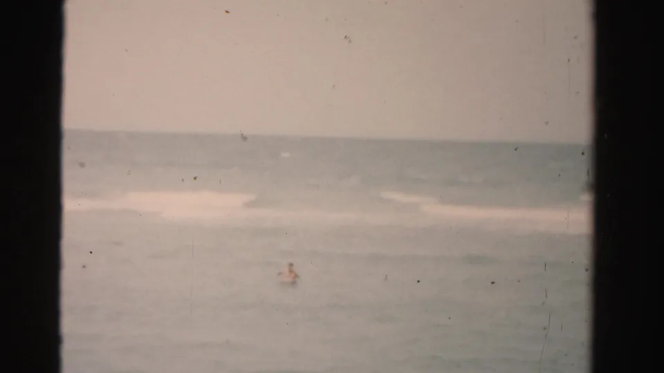Distant swimmer in Dade County ocean water, seen through faded 1950s 8mm color film.