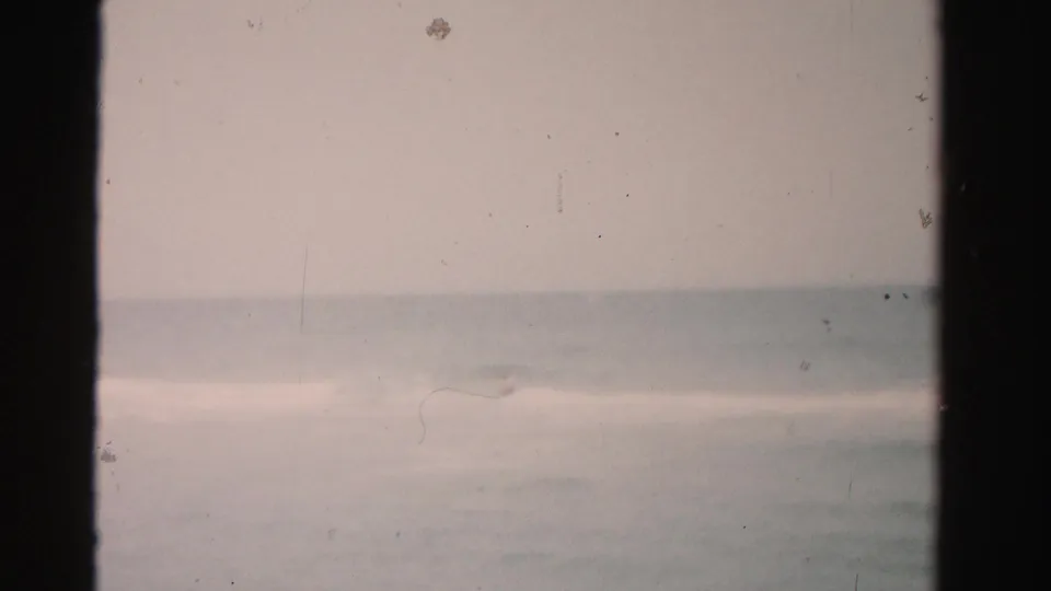 Faded 8mm view of the ocean and horizon in Dade County, with only faint surf detail visible.