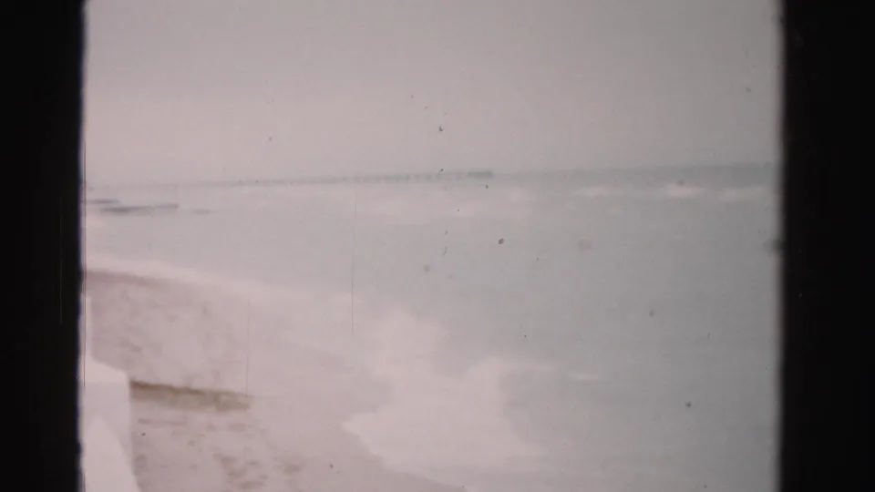 Soft 8mm footage from 1955 Dade County, Florida shows a quiet shoreline, shallow surf, and muted coastal light.