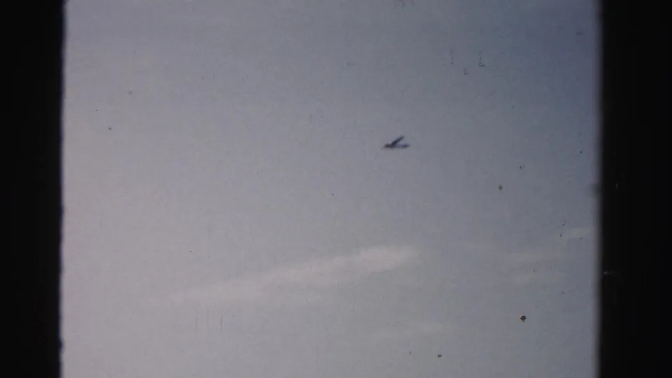 The final frame shifts to a pale sky with a small airplane silhouette, separate from the preceding beach view.
