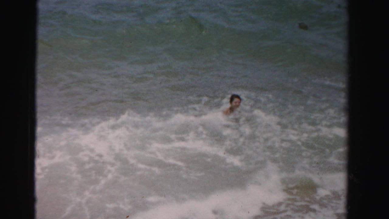 Swimmer's head visible amid churning ocean surf.