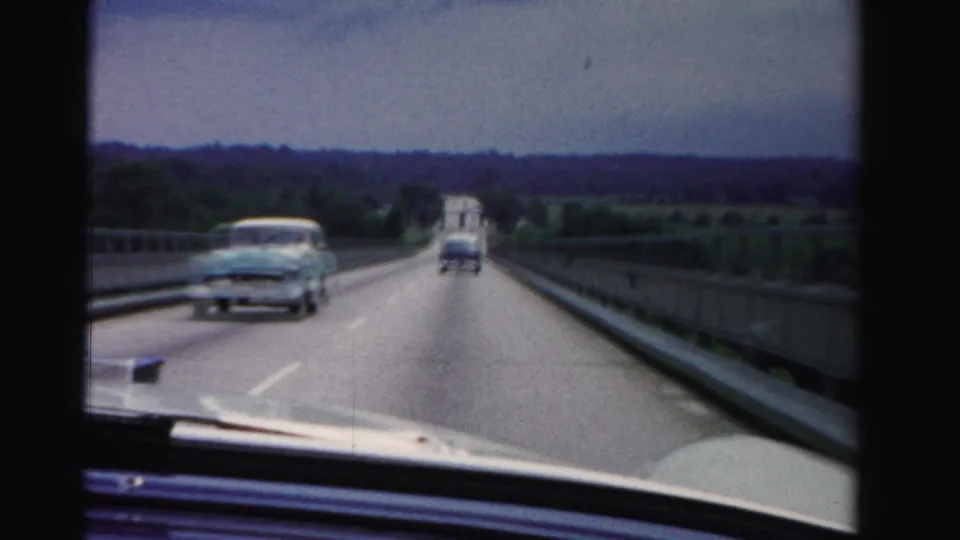1955 Florida bridge-driving frame with a light-colored oncoming sedan passing close to the camera car.