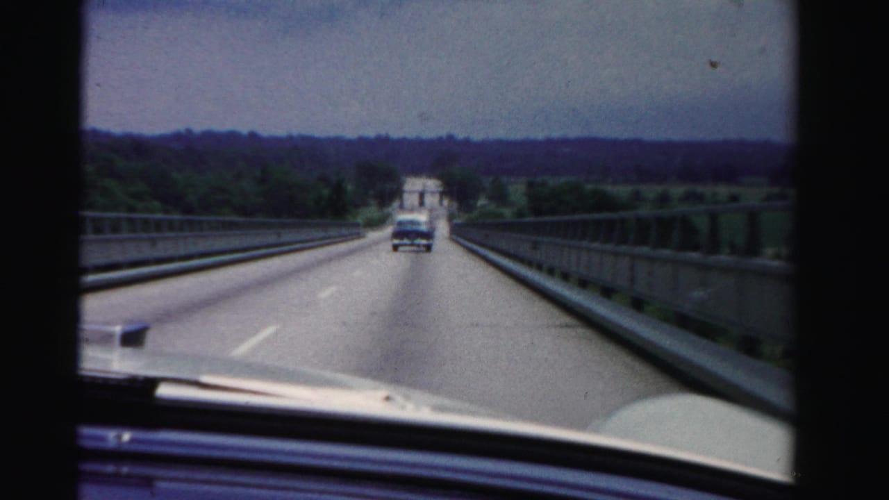 Forward view from a car crossing a bridge behind another vehicle.