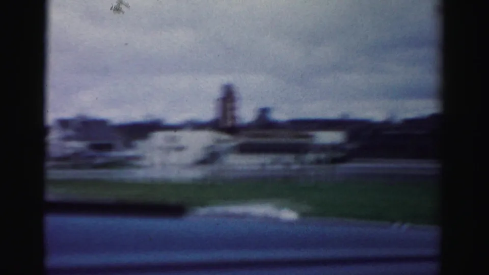 A soft 8mm view looks across floodwater toward distant buildings and a tall industrial-looking structure in Albany metadata context.