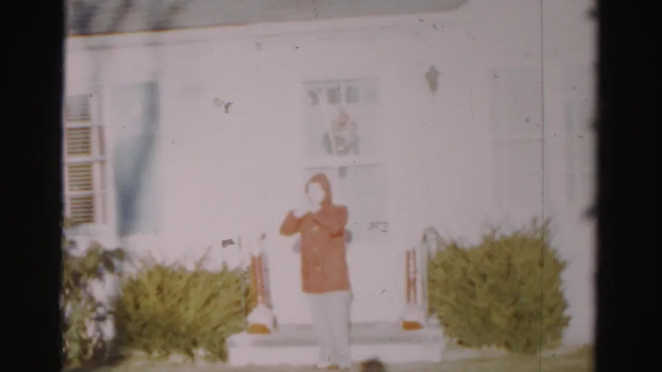 The final frame shows the red-coated person on the front steps of a white Albany house, with shrubs and railings visible.