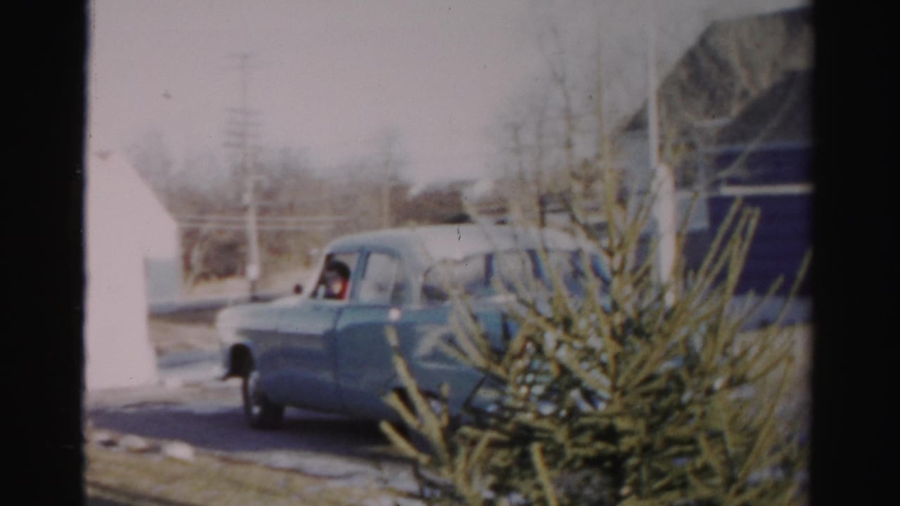 Blue sedan angled near the driveway with a driver visible through the side window.