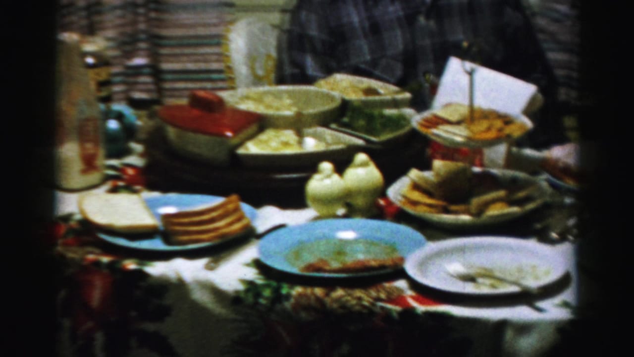 Cluttered dining table with dishes, serving bowls, plates, and a tiered tray.