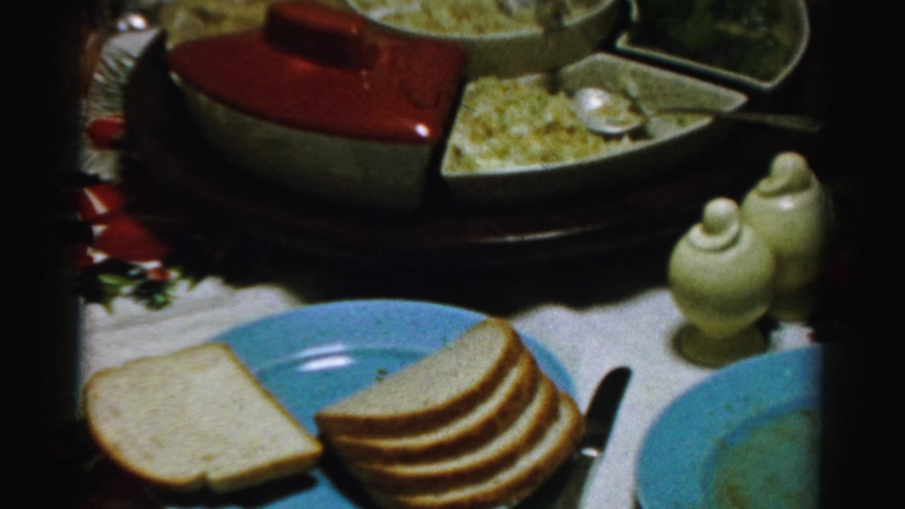 Similar table view with bread, blue plates, serving dish, and small ceramic vessels.